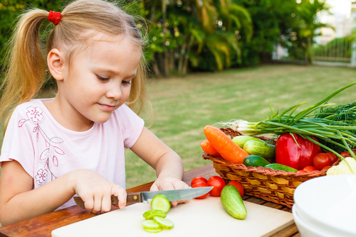 девочка режет овощи