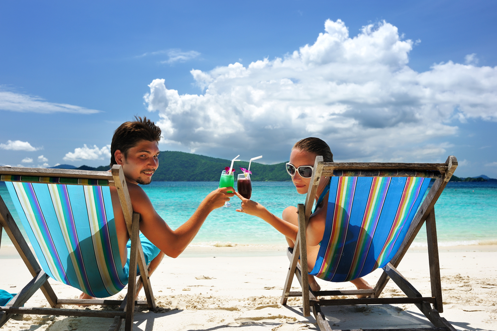 мужчина и женщина пьют коктейли на пляже
