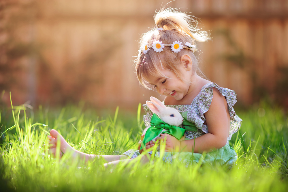 ребенок играет с кроликом