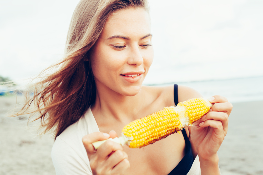 женщина ест кукурузу